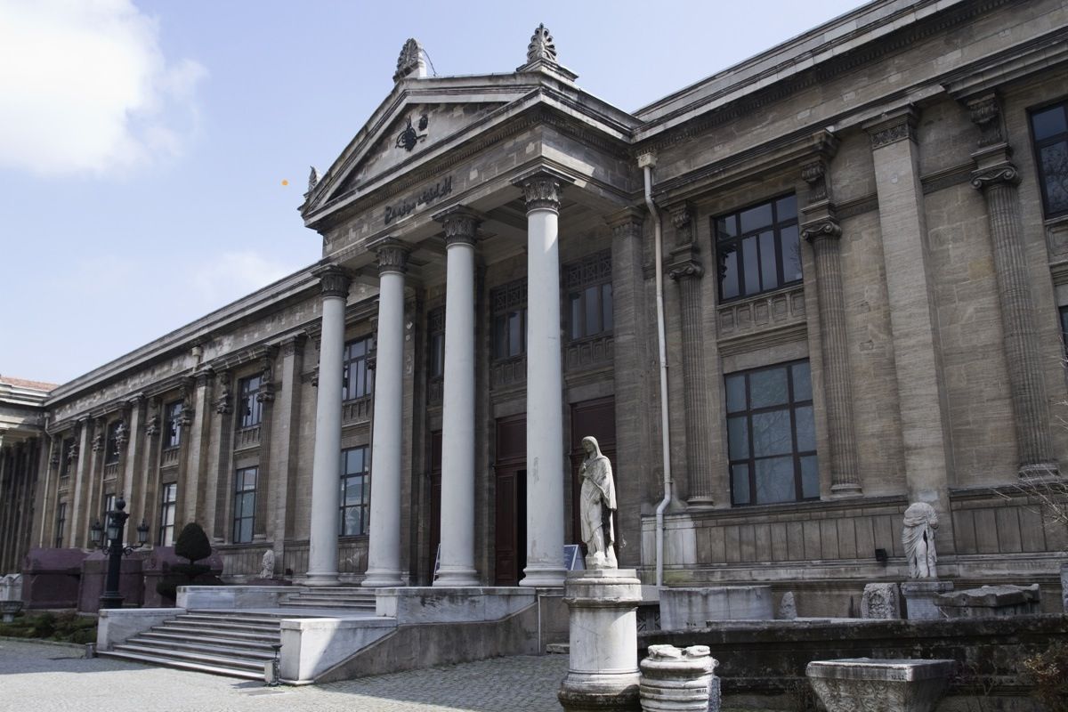 Exterior of the Istanbul Archaeological Museums with columns on the entrance and a statue outside